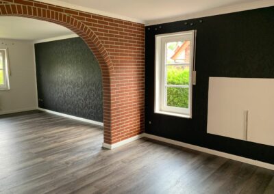 Wohnzimmer mit Bogen und dunkler Wand